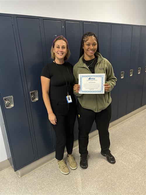 Collegiate Academy's Stairclimber for October, Azariyah Jordan, poses with her certificate and school staff.